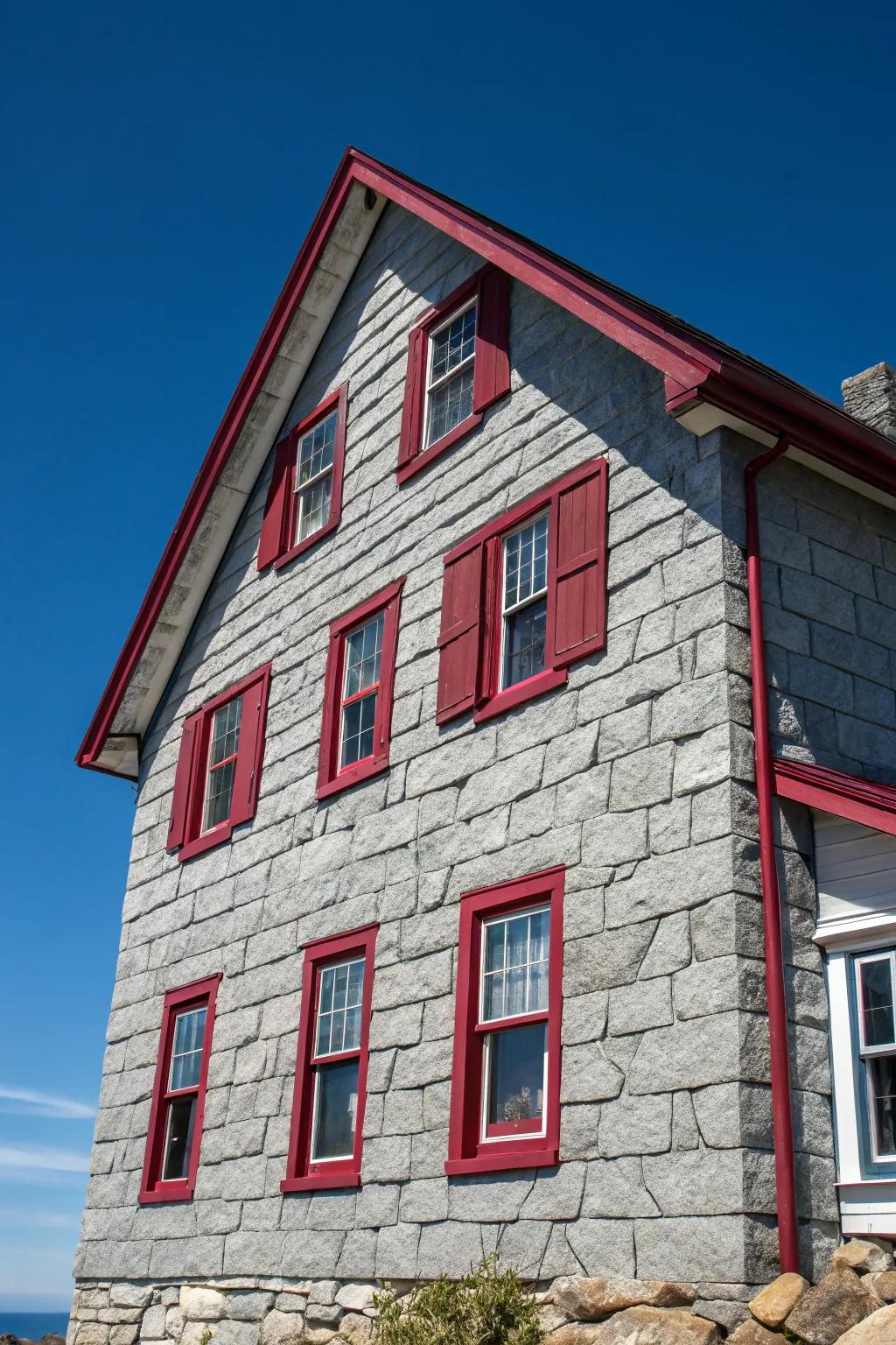 Bold red trims add a surprising contrast to this gray stone facade.